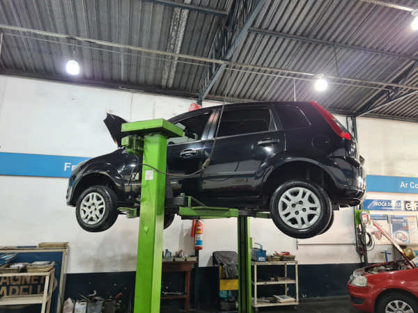 Carro no elevador sendo desmontado